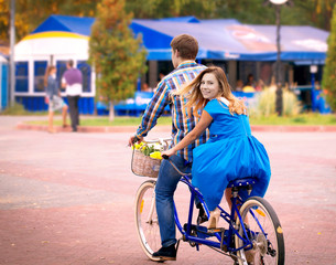 Smiling girl sitting turned around on a tandem bike