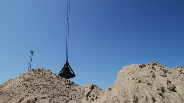 Crane Bucket Transfers Sand in Mining Open Pit
