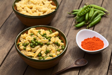 Hungarian vegetarian pea stew seasoned with paprika served with homemade noodles called Nokedli or Galuska in rustic bowl (Selective Focus, Focus on the middle of the dish)