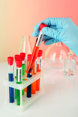 Test tubes with colorful liquid in scientist hand, closeup