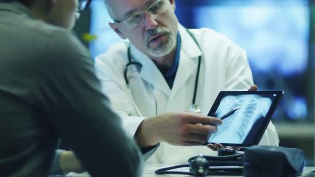 Doctor is Shows X-ray Images to Patient on Tablet PC.