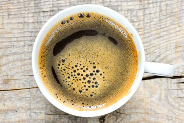 Tasty Coffee in cup on background