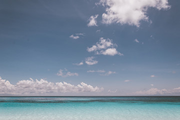 blue sky with sea and beach - soft focus with film filter