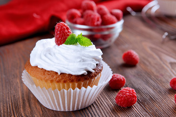 Delicious cupcake with berries and fresh mint on wooden table close up