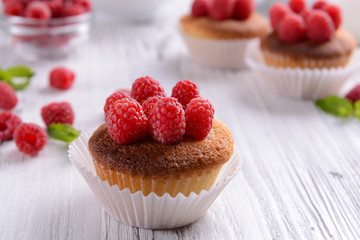 Delicious cupcakes with berries and fresh mint on wooden table close up