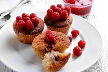 Delicious cupcakes with berries on plate close up