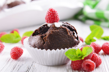 Delicious chocolate cupcake with berries on wooden table close up