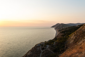 Beautiful sunset by the sea, cliffs and mountains. South resort.