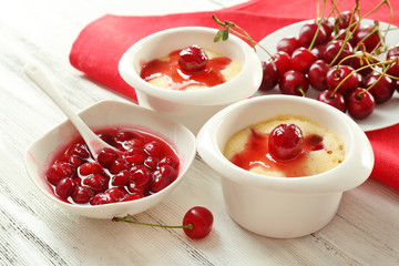 Tasty pudding with cherries on table close up
