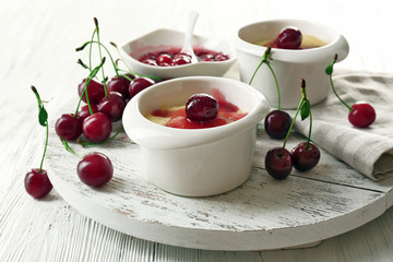 Tasty pudding with cherries on table close up