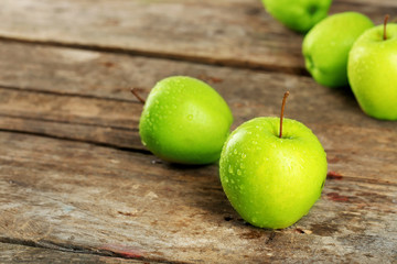 Ripe green apples on wooden table close up