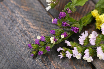 Beautiful wild flowers on wooden table close up