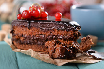 Tasty chocolate cake with berries and cup of tea on table close up
