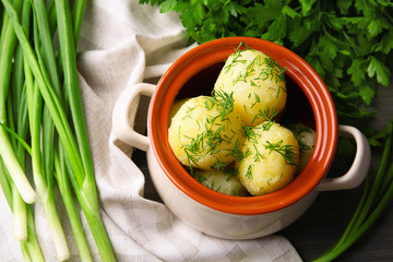 Boiled potatoes with dill in pan on table close up