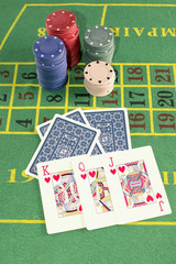 Poker cards with chips on green carpet.