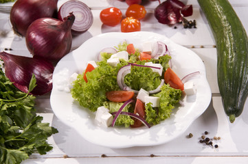 Fresh salad with autumn vegetables on white wooden planks 
