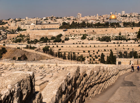 JERUSALEM, ISRAEL - July 13, 2015: Old jewish graves on the mount of olives in Jerusalem, with on the back the temple mount with the dome of the rock