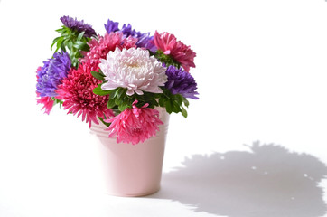 Bouquet of asters in a decorative bucket