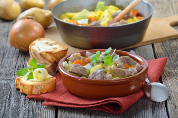 Irish Stew mit Lammfleisch, Kartoffeln und weiterem Gemüse in der Keramikschale serviert