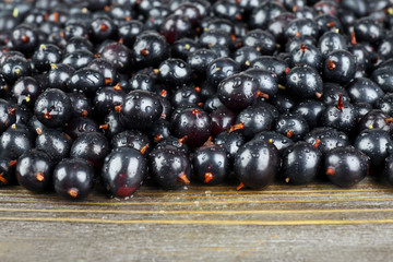 Heap of wild black currant on wooden table close up