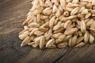 Spoon of Raw Organic Spelt Grain close up on a table