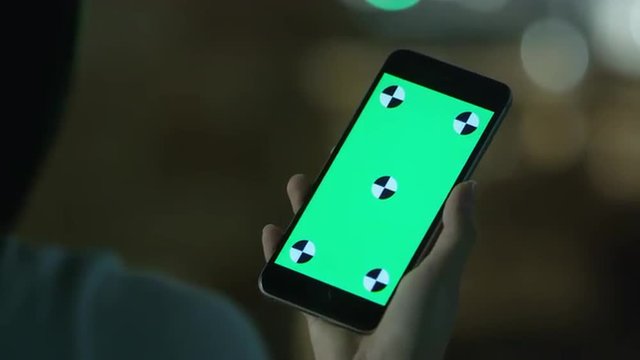Young Girl is Holding Phablet with Green Screen at Evening Time. Casual Lifestyle.