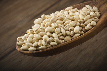 Spoon of Pearl barley close up on a table