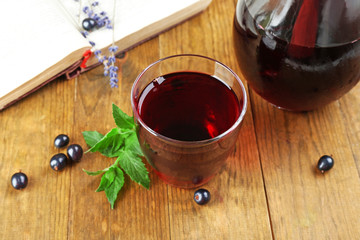 Fresh currant juice with berries and book on table close up