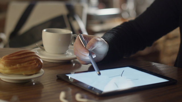 Woman Drawing on Tablet PC in Coffee Shop 2