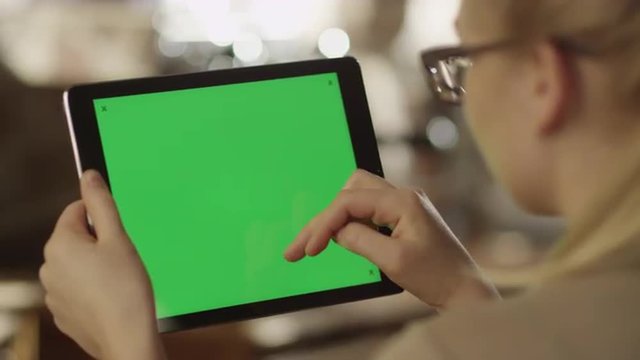 Girl Using Tablet with Green Screen in Landscape Mode in Coffee Shop