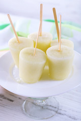 Melon ice lolly on table on light blurred background