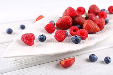Tasty ripe berries on wooden table close up