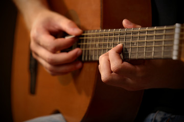 Obraz premium Young musician playing acoustic guitar close up