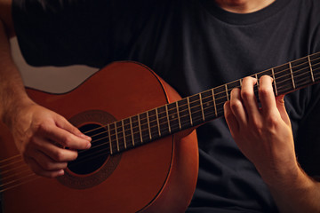 Fototapeta na wymiar Young musician playing acoustic guitar close up