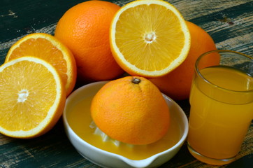 Fine art still life with orange juice and porcelain juicer on wooden table