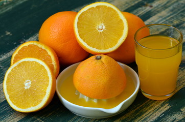 Fine art still life with orange juice and porcelain juicer on wooden table