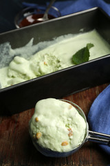 Homemade ice cream in frozen metallic container on dark wooden background