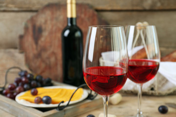Still life of wine, grape, cheese and bread on rustic wooden background