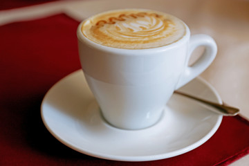 Cup of cappuccino on wooden table, closeup