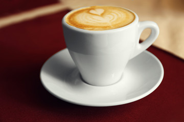 Cup of cappuccino on wooden table, closeup