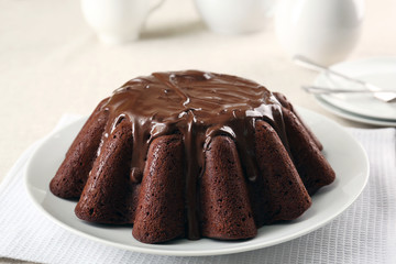 Tasty chocolate muffin with glaze on table close up
