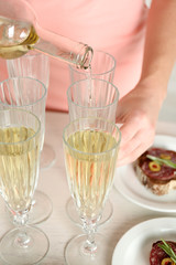 Woman pouring wine into glass, close up