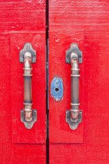 Door handles on red wooden door