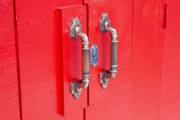 Door handles on red wooden door