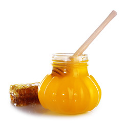 Pot of honey, wooden dipper and honeycomb isolated on white