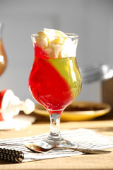 Tasty Jelly desserts with cream on light background