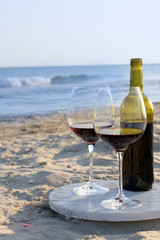 Wine bottle and glasses on the seashore