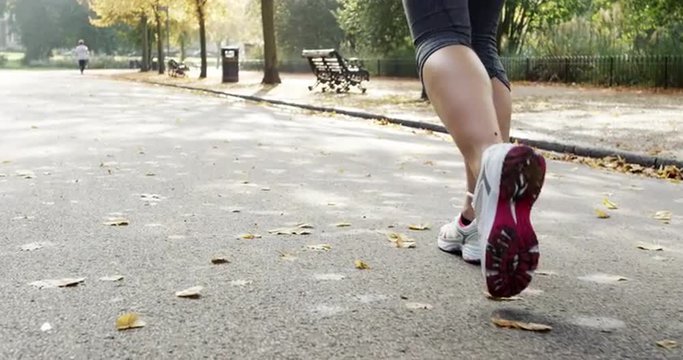 Close up feet running Runner woman in park exercising outdoors