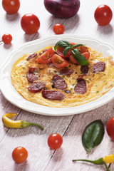 Omelet with pepperoni sausage and cherry tomato