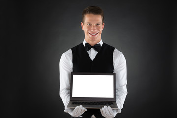 Happy Waiter Showing Laptop